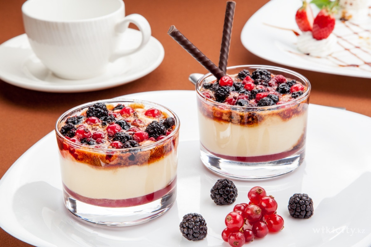 Фото У Афанасича - Almaty. Сливочно - ванильный десерт,с малиновым соусом и лесными ягодами,покрытый карамелью