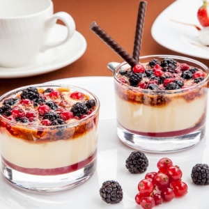 Фото У Афанасича - Алматы. Сливочно - ванильный десерт,с малиновым соусом и лесными ягодами,покрытый карамелью